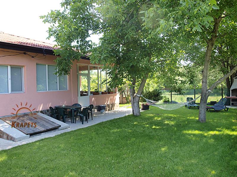 un patio trasero con una hamaca y una casa en Nadya Holiday Home, en Krapets