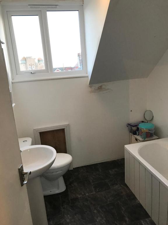 a bathroom with a sink and a toilet and a window at Blackpool Home with Tower View in Blackpool