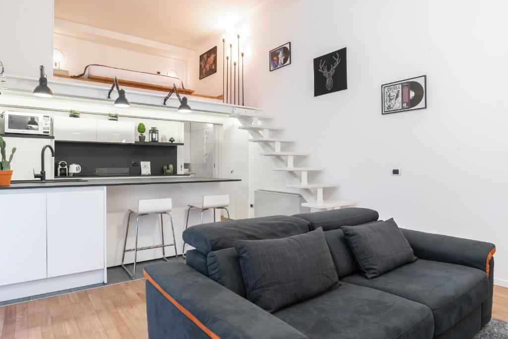 a living room with a couch and a kitchen at Urban District Apartments - Milan Isola Lancetti Loft 1BR in Milan