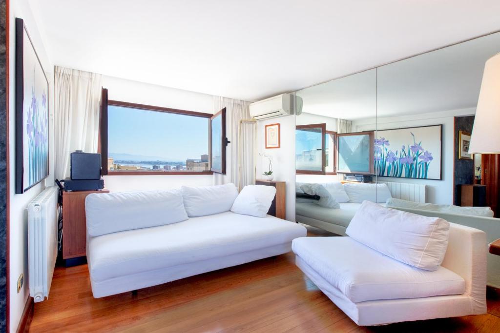 un soggiorno con due divani bianchi e una grande finestra di Cagliari Upper House a Cagliari