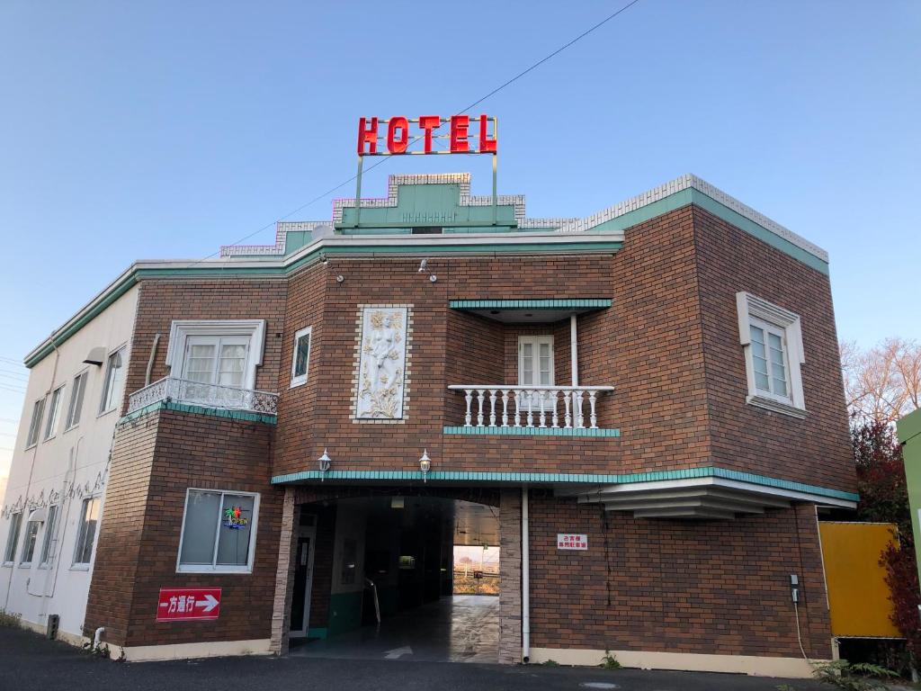 um edifício de tijolos vermelhos com uma placa de hotel em Hotel Oasis (Adult Only) em Fukaya