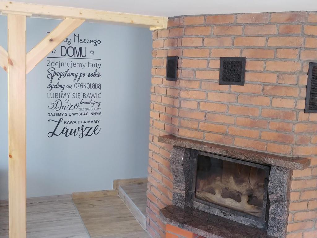 a brick fireplace with a sign on the wall at Apartament w Karkonoszach in Podgórzyn