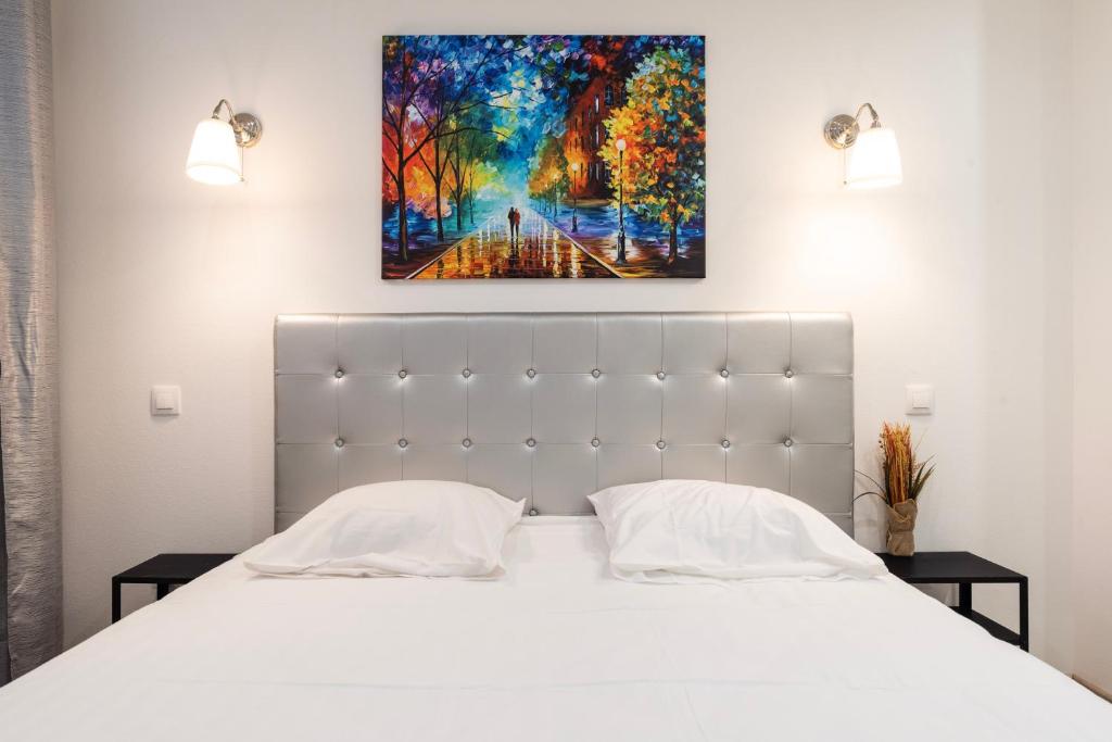une chambre avec un lit blanc et un tableau au mur dans l'établissement CityCosy Strasbourg - T2 Hirtz Orangerie, à Strasbourg