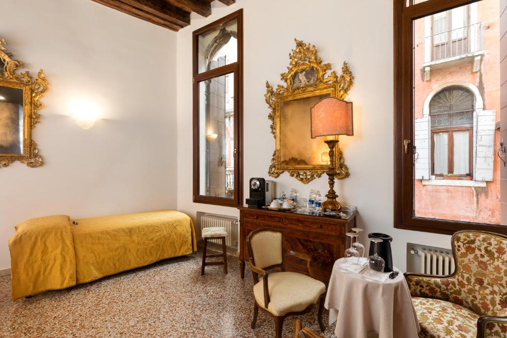 a bedroom with a bed and a mirror and a table at Luxury Venetian Rooms in Venice