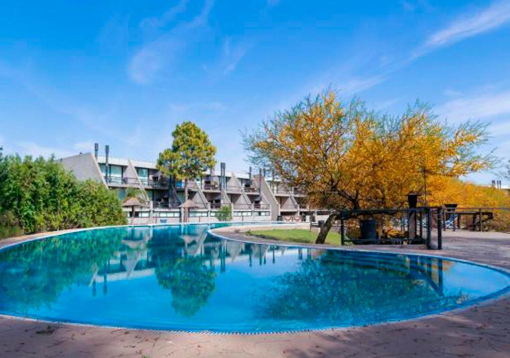 a large pool with blue water in front of a building at Lofts - Club de campo San Pedro in San Pedro