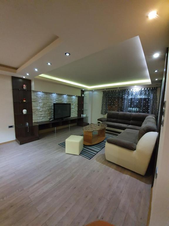uma sala de estar com um sofá e uma televisão em Apartman Marković em Bosanski Šamac