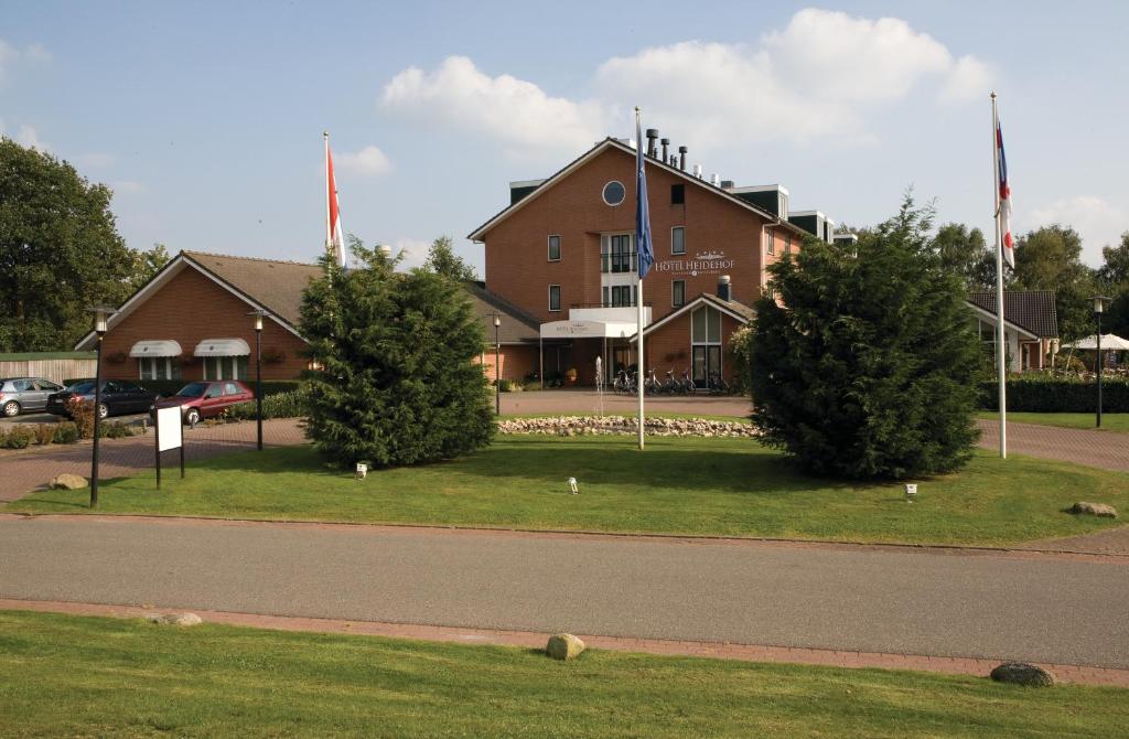 ein Gebäude mit zwei Bäumen vor einer Straße in der Unterkunft Fletcher Hotel Restaurant Heidehof in Heerenveen