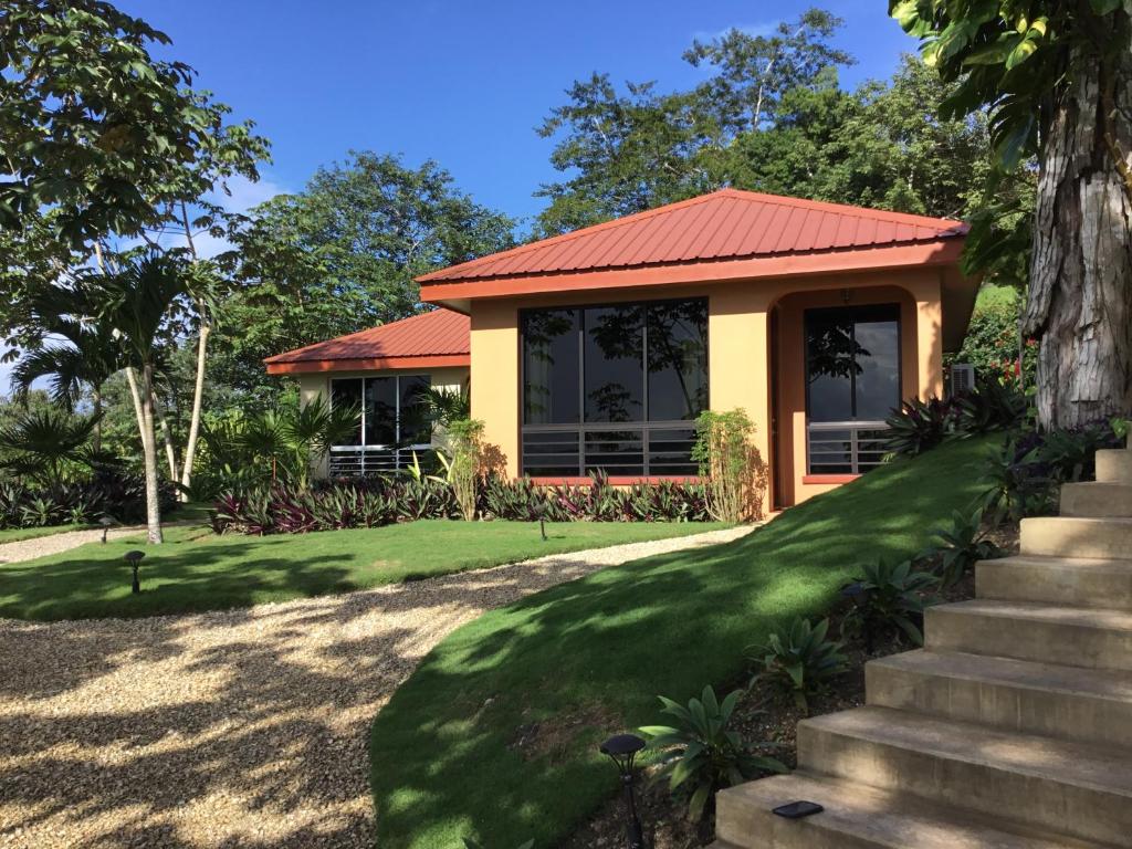 ein Haus mit rotem Dach und grünem Rasen in der Unterkunft Villa Cayo in San Ignacio
