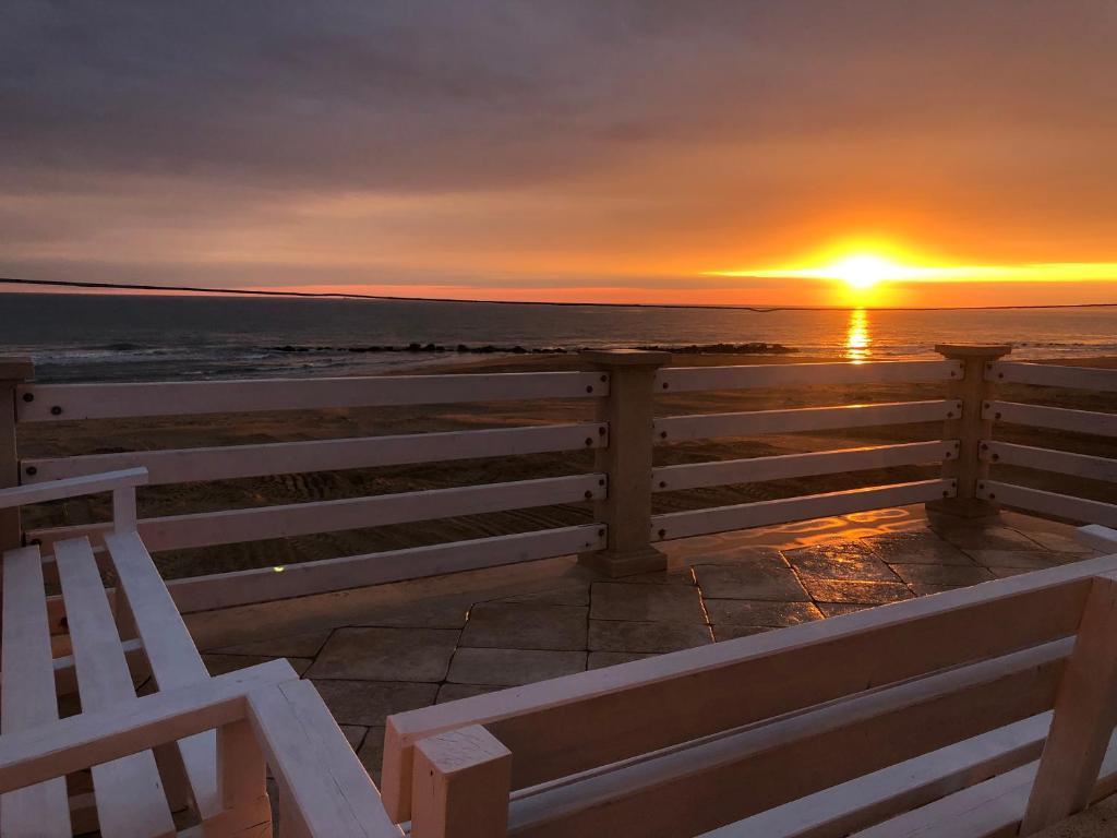 a bench in front of a sunset over the ocean at Casa Mia in Donnalucata