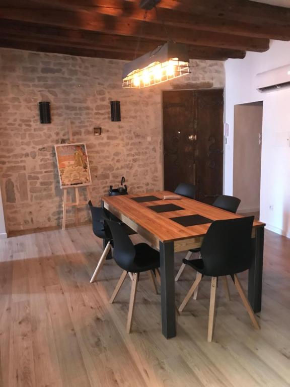 a dining room with a wooden table and chairs at le logis de l’étoile in Nîmes