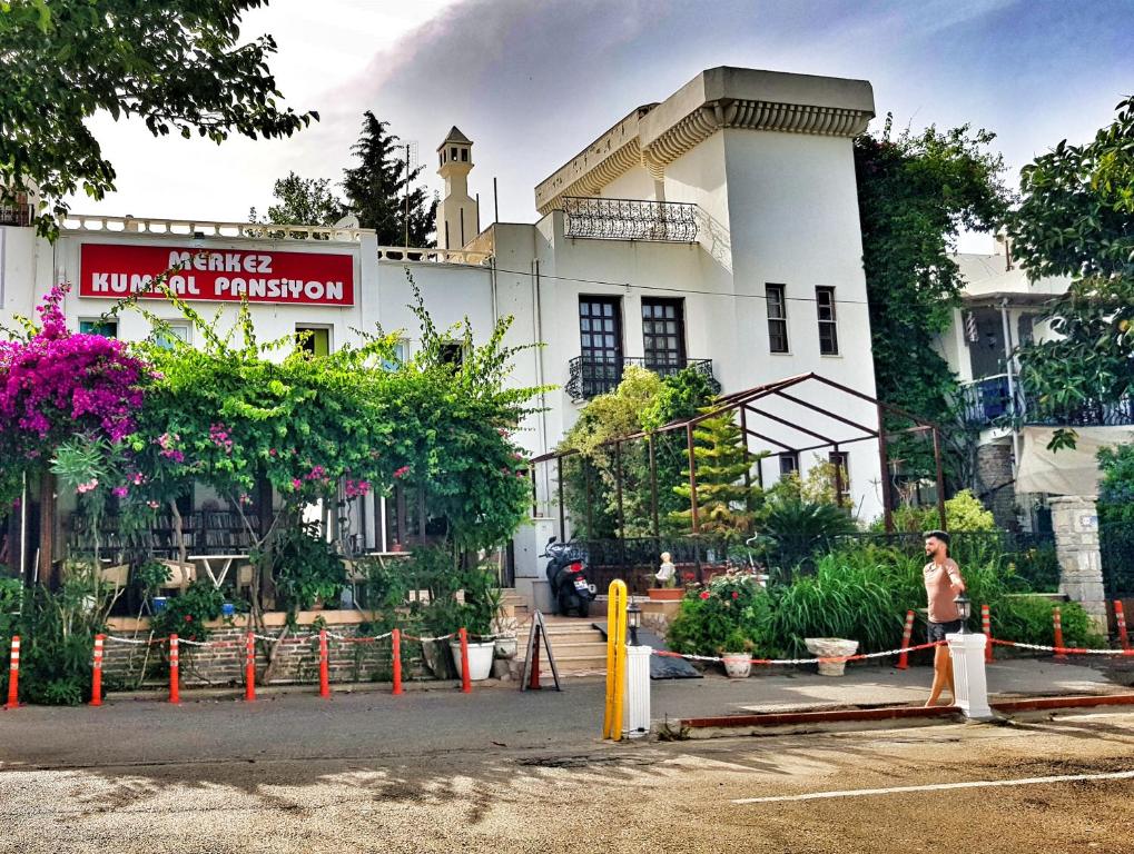 a man is standing in front of a building at Merkez Kumsal Pansiyon in Bodrum City
