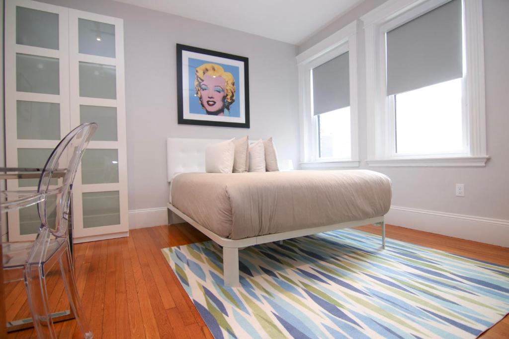 een slaapkamer met een bed en een tafel en ramen bij A Stylish Stay w/ a Queen Bed, Heated Floors.. #11 in Brookline