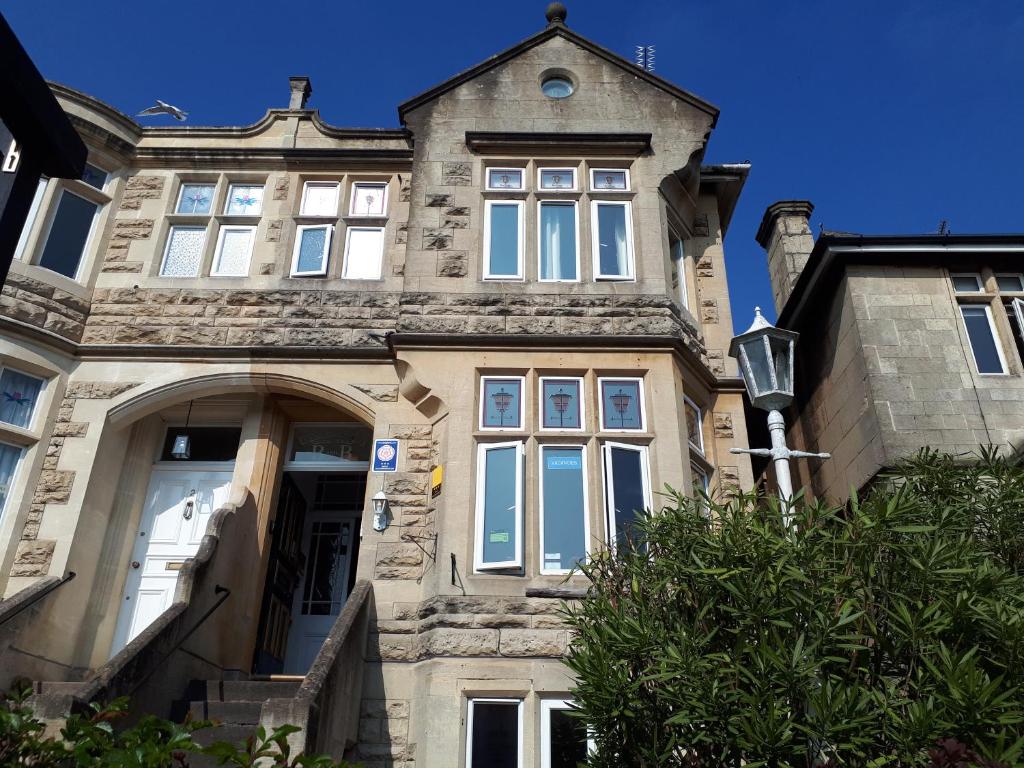 a large stone house with a large window at OYO No 3 in Bath