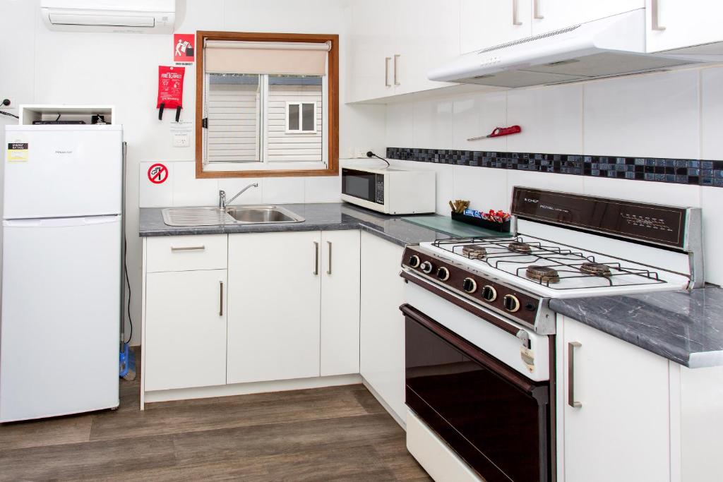 a kitchen with white cabinets and a stove top oven at Ingenia Holidays Torquay Australia in Torquay
