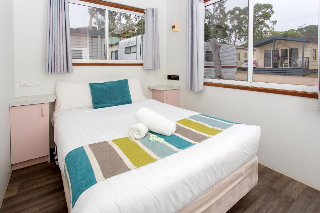 a bedroom with a large bed in a room with windows at Ingenia Holidays Torquay Australia in Torquay