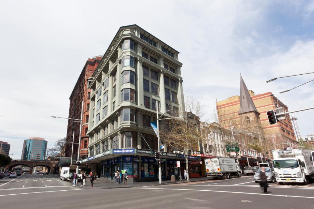 een hoog gebouw in een stadsstraat met een verkeerslicht bij 790 on George Backpackers in Sydney