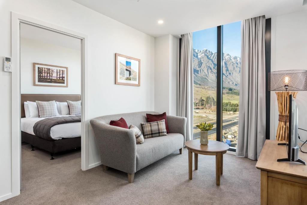 Habitación de hotel con cama, sofá y ventana en Kawarau View, en Queenstown