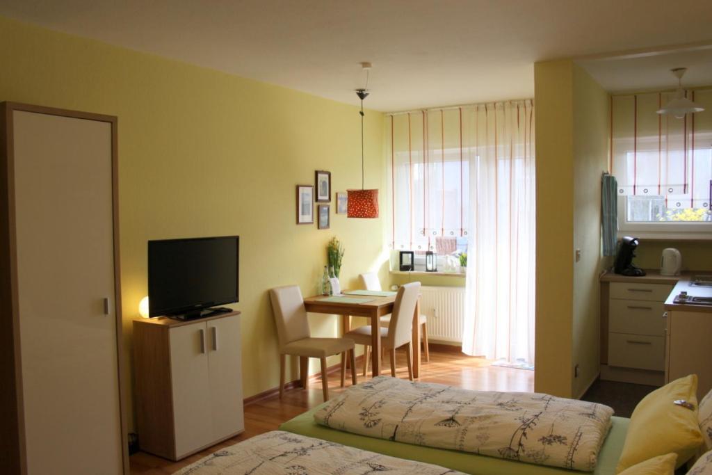 ein Wohnzimmer mit einem Tisch und einem TV im Zimmer in der Unterkunft Ferienwohnung Markmann in Schwabach