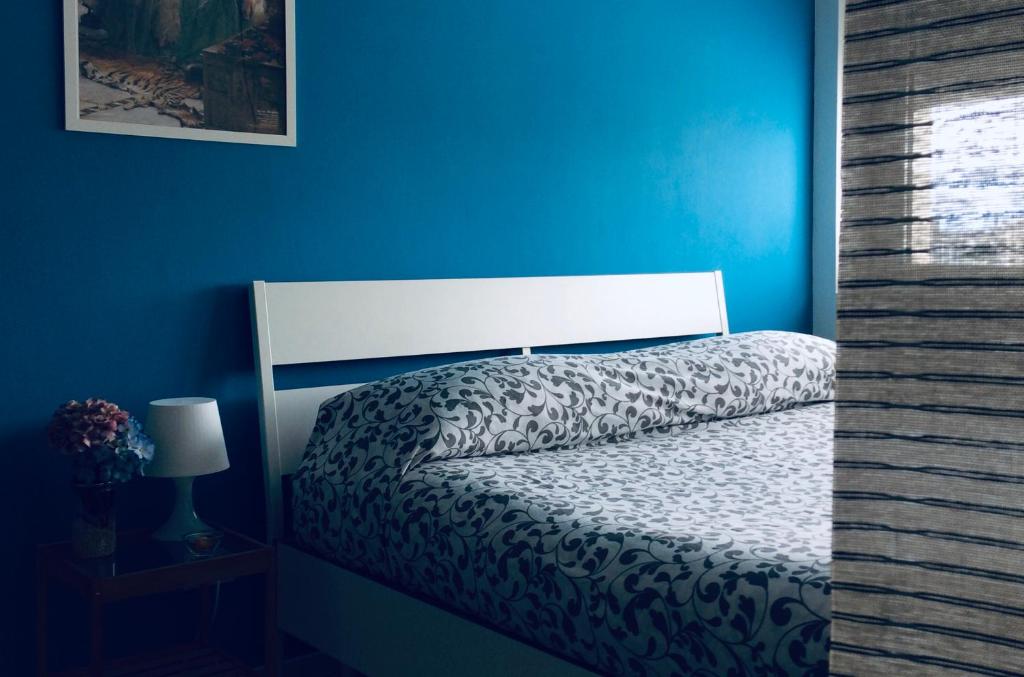ペスカーラにあるSmart apartment Mare & Movidaの青い壁のベッドルーム(ベッド1台付)