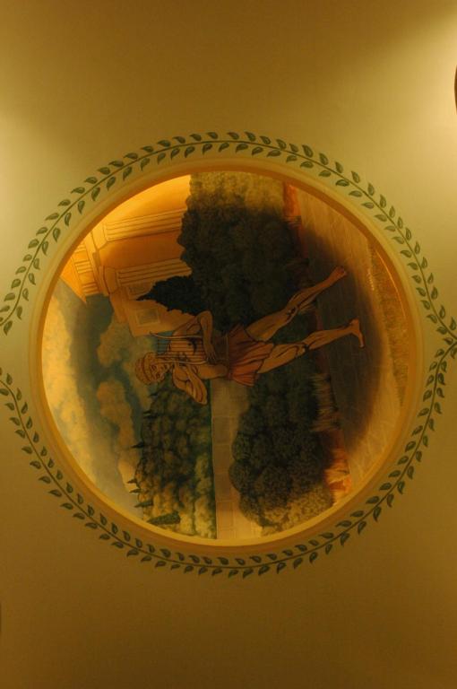 a reflection of a clock in a mirror at Orfeas Hotel in Mytilini