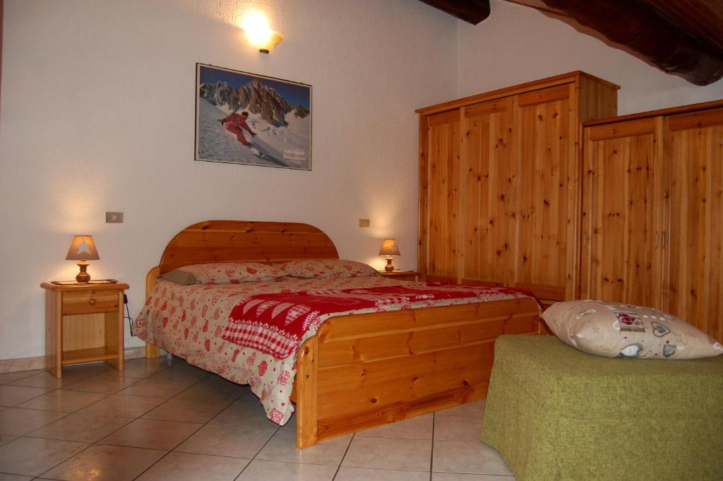 sypialnia z drewnianym łóżkiem i 2 szafkami nocnymi w obiekcie Case Gran Paradiso Rhemes Saint Georges w mieście Rhemes-Saint-Georges