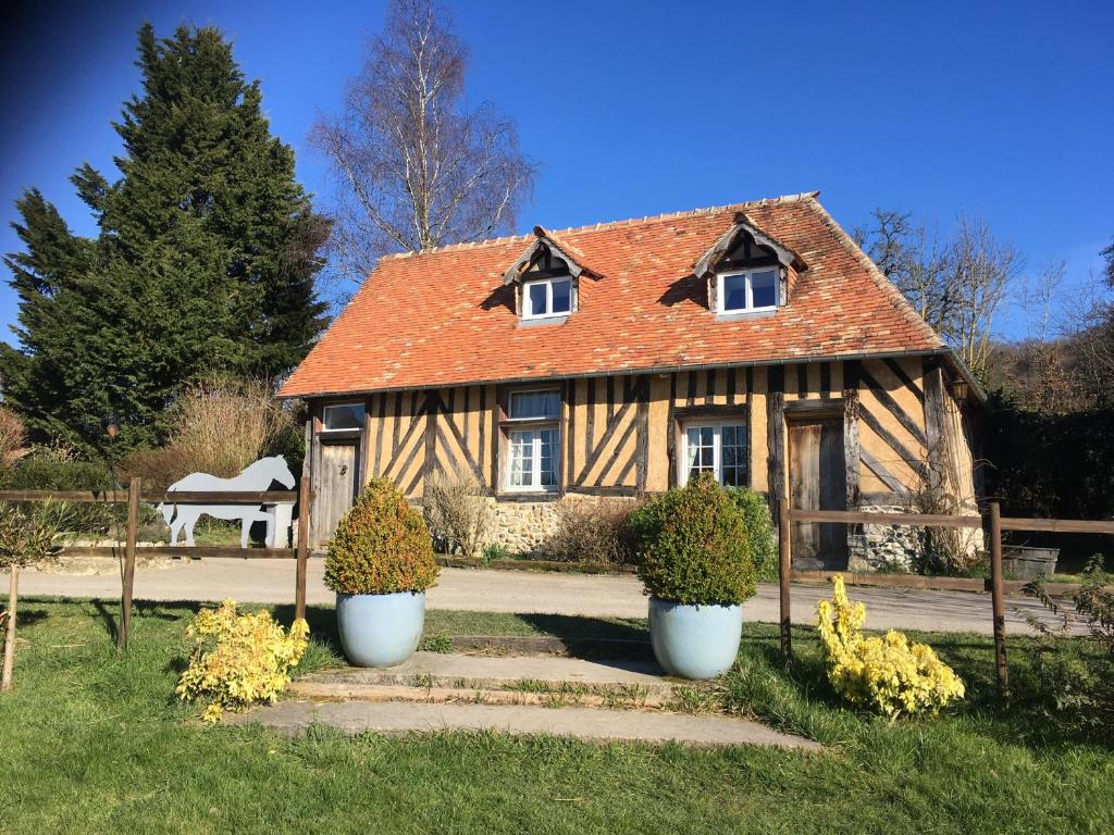 a house with two white pots in front of it at La Chevalerie in Pont-lʼÉvêque