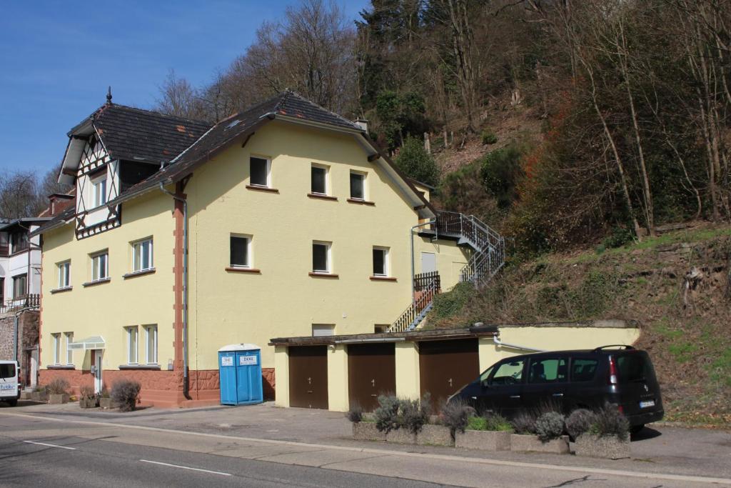 a yellow house with a car parked in front of it at Gästehaus Windheim (Ettlingen) in Ettlingen