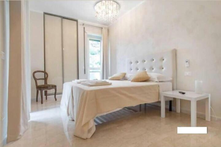 a white bedroom with a large bed and a chair at Let's go to Rome in Rome