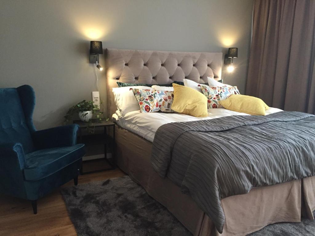 um quarto com uma cama grande e uma cadeira azul em Hotel Falun em Falun
