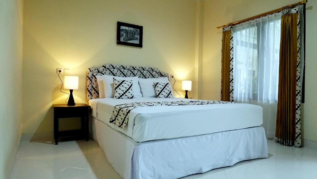 Una cama o camas en una habitación de Diana Hotel Jogja