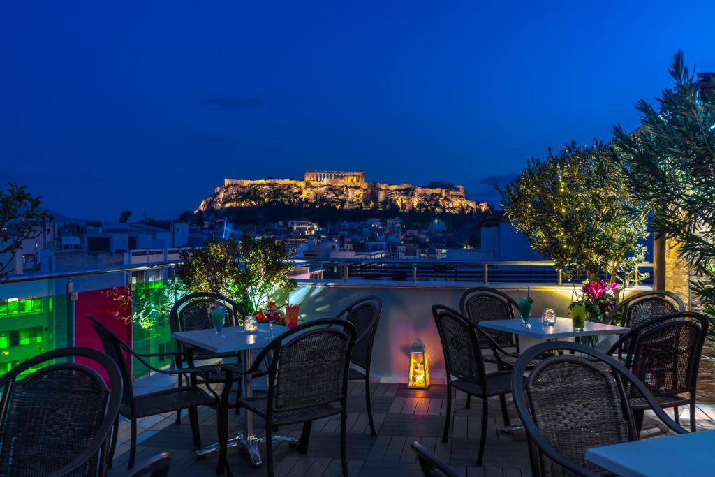 een patio met tafels en stoelen en uitzicht op kippen bij Attalos Hotel in Athene