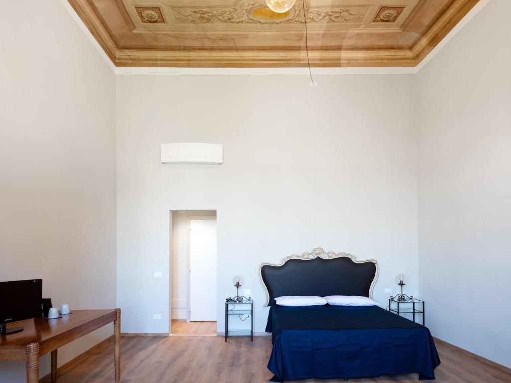a bedroom with a bed and a wooden ceiling at B&B Stupido Hotel in Florence