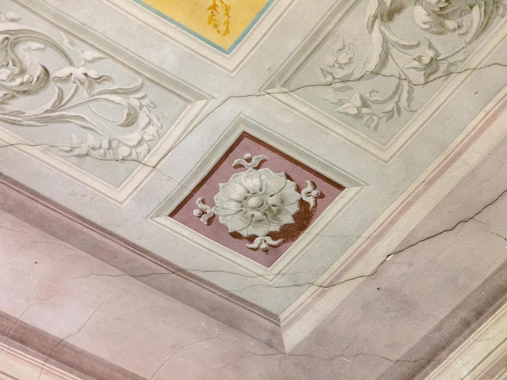 a ceiling in a building with a flower on it at B&B Stupido Hotel in Florence