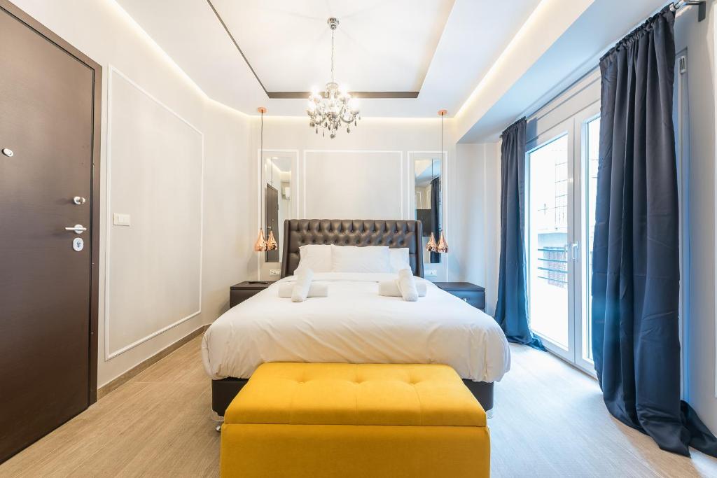a bedroom with a bed and a yellow ottoman at Syntagma Luxury Living One “LL1” Apartments in Athens