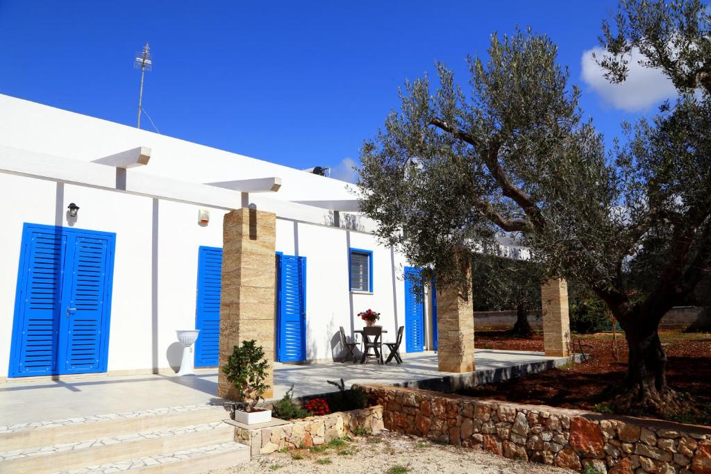 une maison blanche avec des volets bleus et une table dans l'établissement A CASA DI GIUSEPPE, à Sant'Isidoro