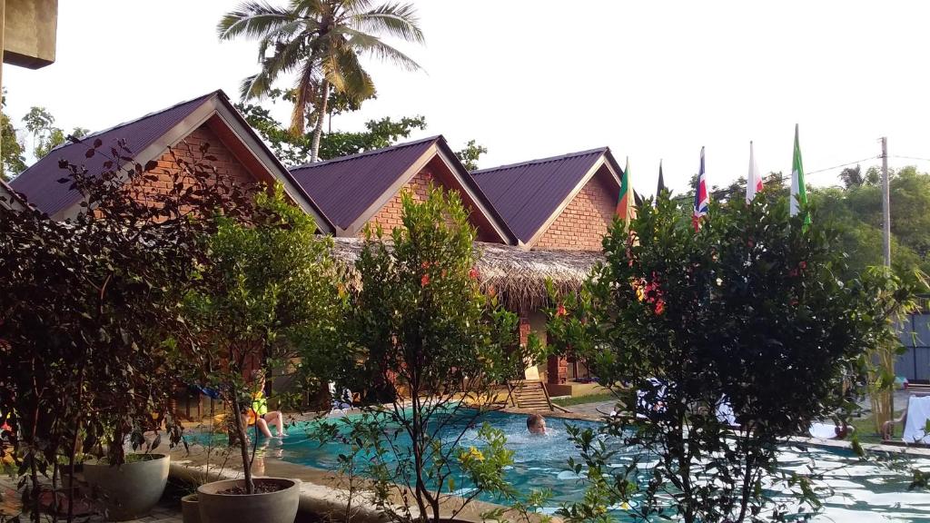 a resort with a pool in front of a building at Negombo The Nature Villa and Cabanas in Negombo