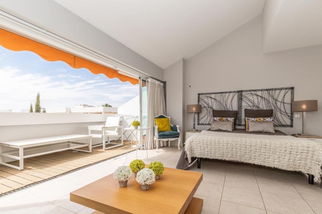 カバナス・デ・タビラにあるCabanas Green Apartment Ria Formosaのベッドルーム1室(ベッド1台、ソファ、テーブル付)