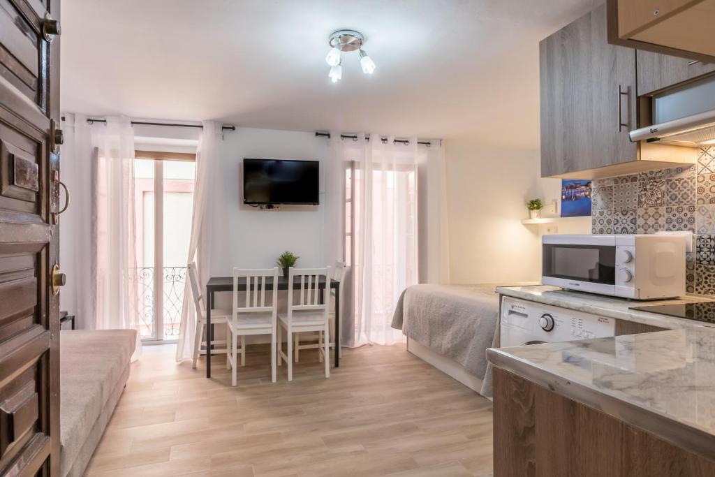 cocina y sala de estar con cama y mesa en Sagasta Apartamento en pleno centro de Sevilla, en Sevilla