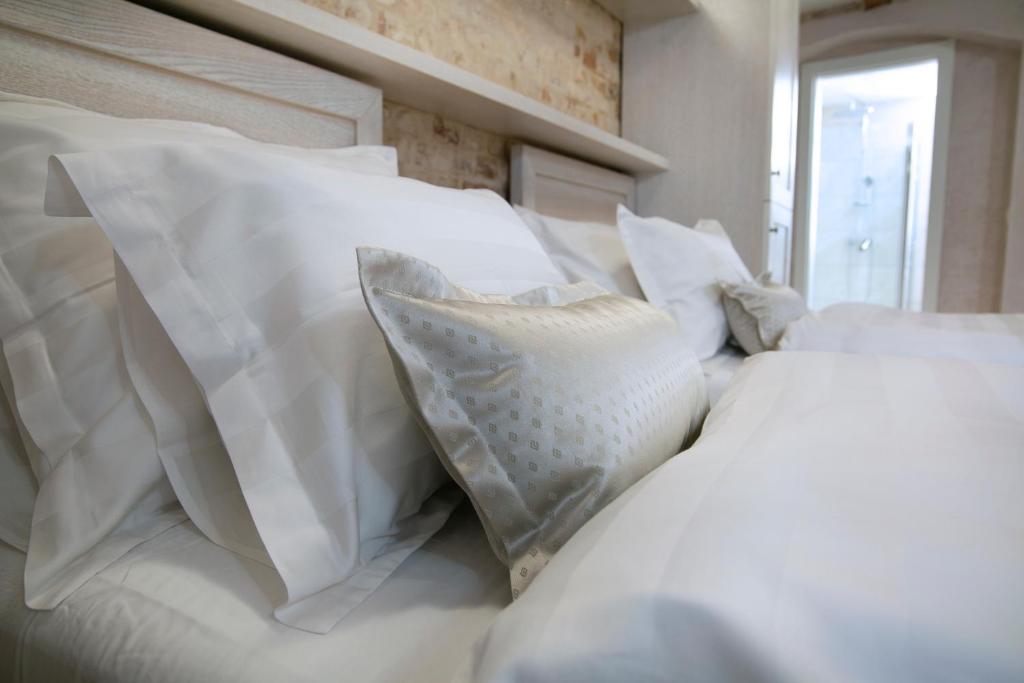 a white bed with white pillows on it at Villa Matejuska Heritage in Split