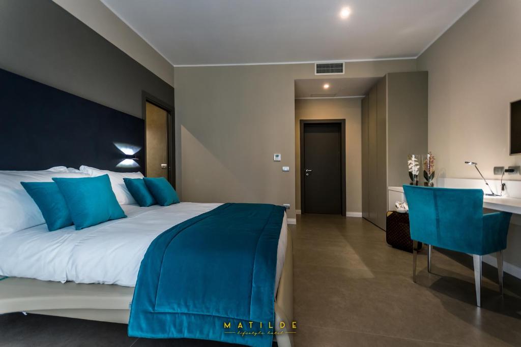 ein Schlafzimmer mit einem großen Bett mit blauen Kissen in der Unterkunft Hotel Matilde - Lifestyle Hotel in Neapel