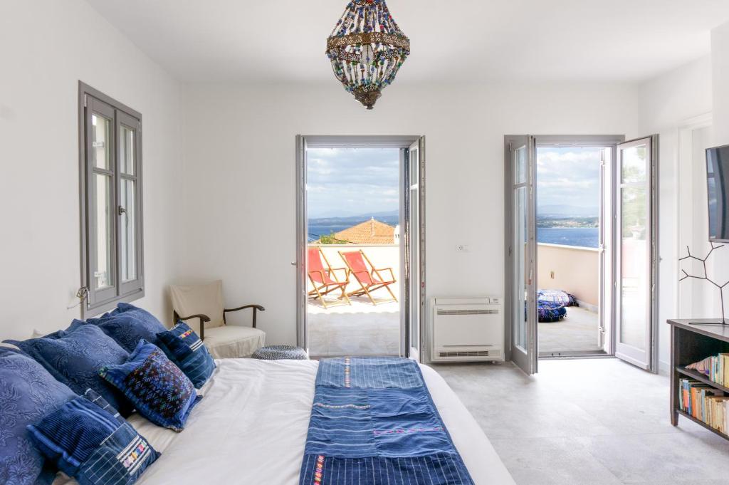 a bedroom with a bed and a view of the ocean at Maison Suisse with sea view in Spetses town in Spetses