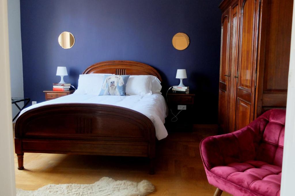 - une chambre bleue avec un lit et une chaise dans l'établissement Chez Thomas, à Colmar