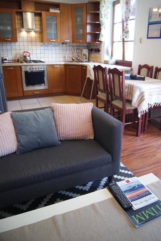 a living room with a couch and a kitchen at Przybobrze Apt. in Jelenia Góra