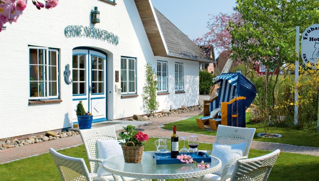 a patio with a table and chairs and a building at Hotel Ekke Nekkepenn in Nebel