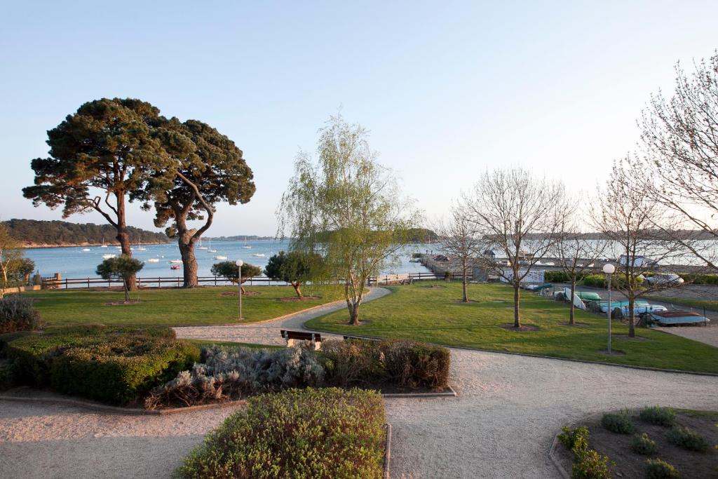 un parc avec vue sur l'eau et les arbres dans l'établissement VVF Résidence Golfe du Morbihan, à Larmor-Baden