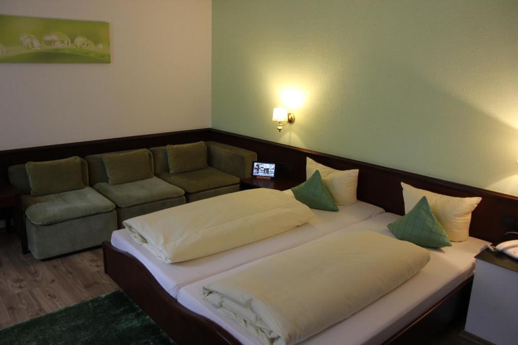 1 Schlafzimmer mit 2 Betten und einem Sofa in der Unterkunft Hotel Lamm in Weinstadt