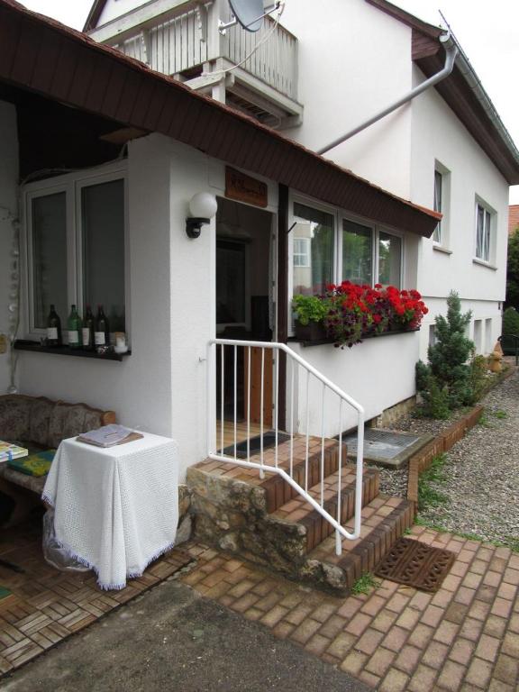 une maison blanche avec une table devant elle dans l'établissement Ferienwohnungen Gollkowsky, à Rudolstadt