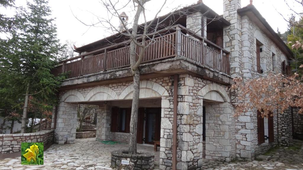 een stenen gebouw met een balkon erboven bij Filia House - Kalavryta in Klitoria