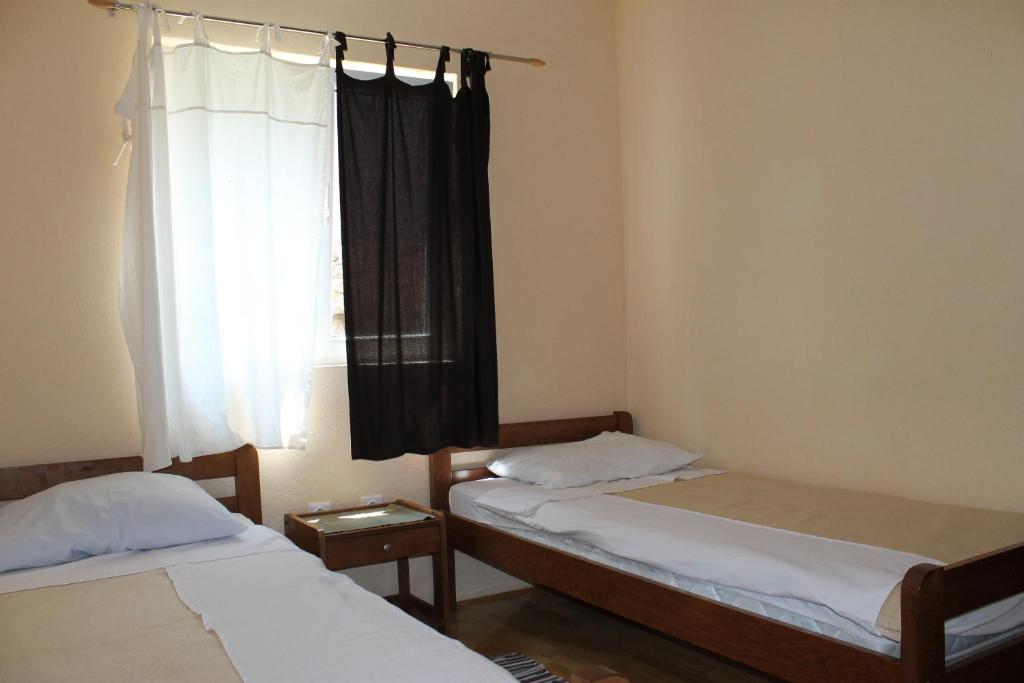 dwa łóżka pojedyncze w pokoju z oknem w obiekcie Apartments Isabela w Bašce