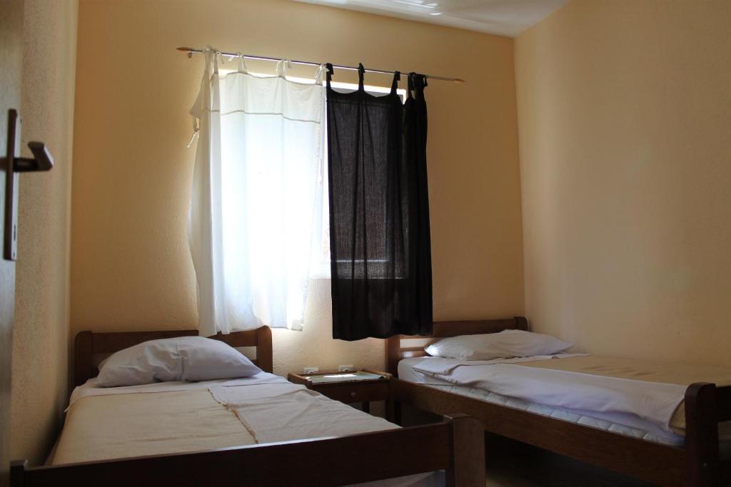 dwa łóżka w pokoju z oknem w obiekcie Apartments Isabela w Bašce